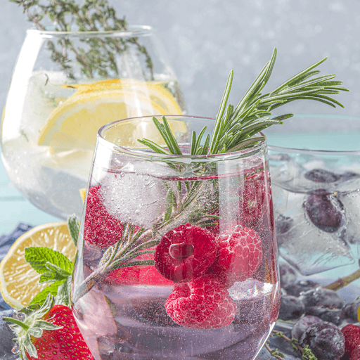 Berry gin and tonic cocktail with raspberries and rosemary garnish