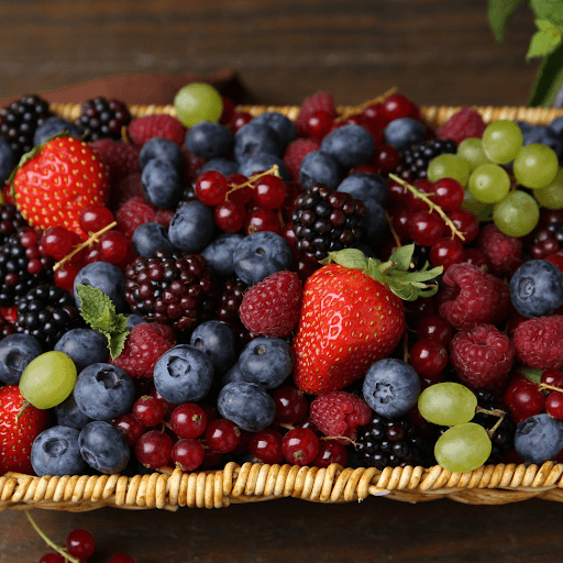 Fresh mixed berries including strawberries, blueberries, grapes, and raspberries